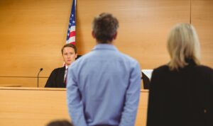 Image of defendant and lawyer in front of a judge.