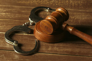 Image of unlocked handcuffs next to a judge's gavel