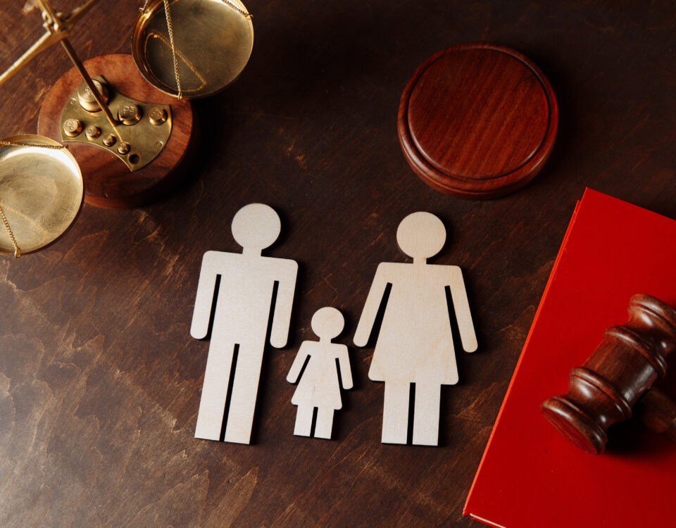 Mother and father figures with child in the. middle next to a judge's gavel.