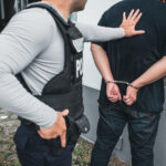 Suspect being detained by police officer and advised of his legal rights.