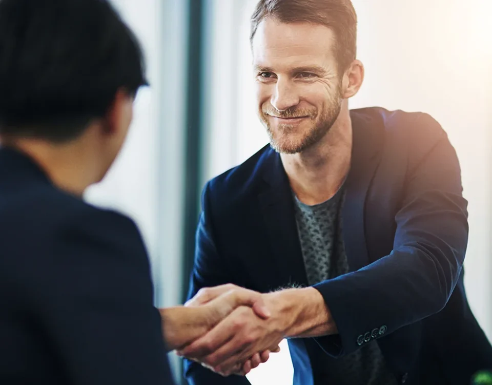 Business, people and handshake in office with agreement in investment deal, funding proposal success or welcome. Space, financial advisor and shaking hands in collaboration of partnership with banner.